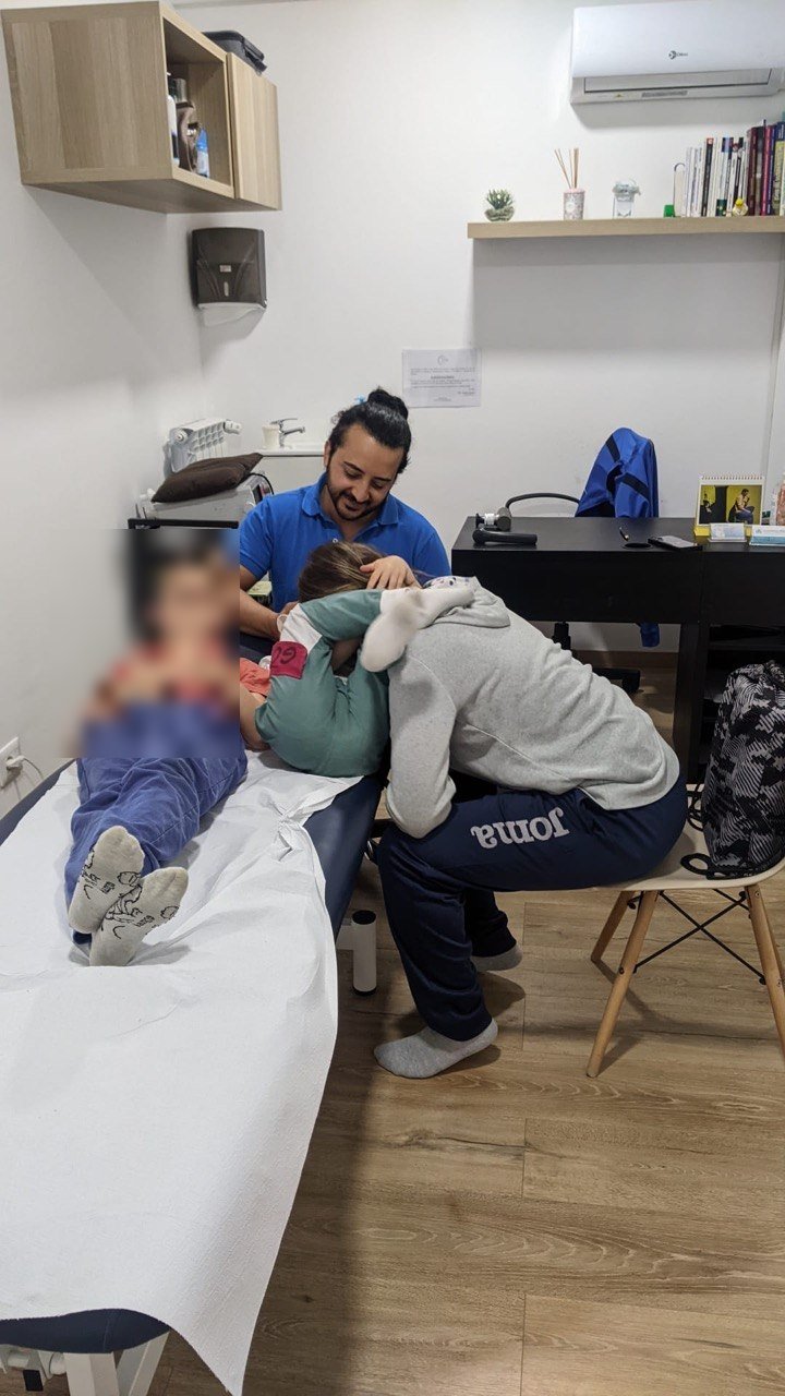 Trattamento osteopatico pediatrico in studio, volti dei minori oscurati per privacy